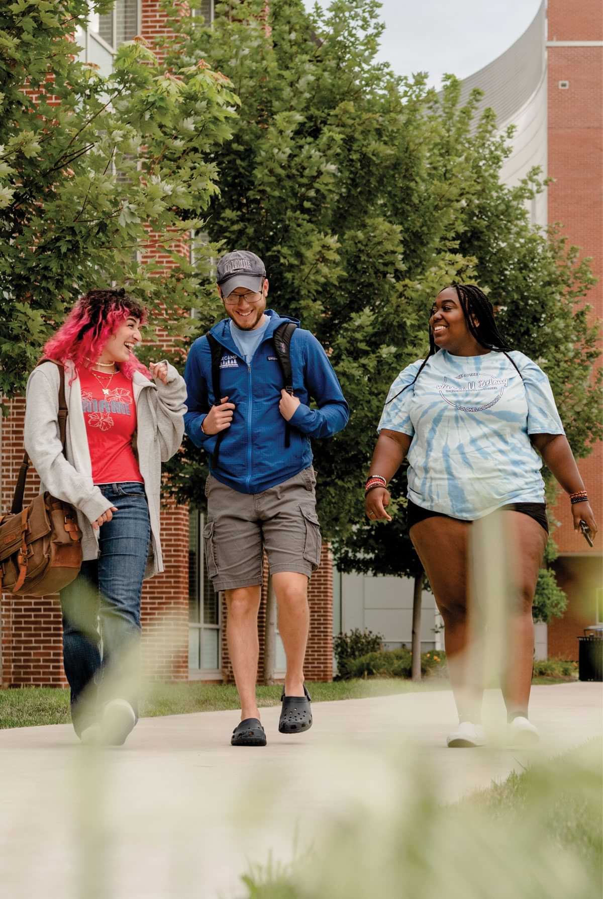 Three students walking and talking on campus