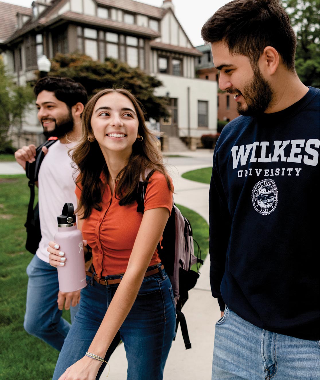 Three students walking and talking on campus